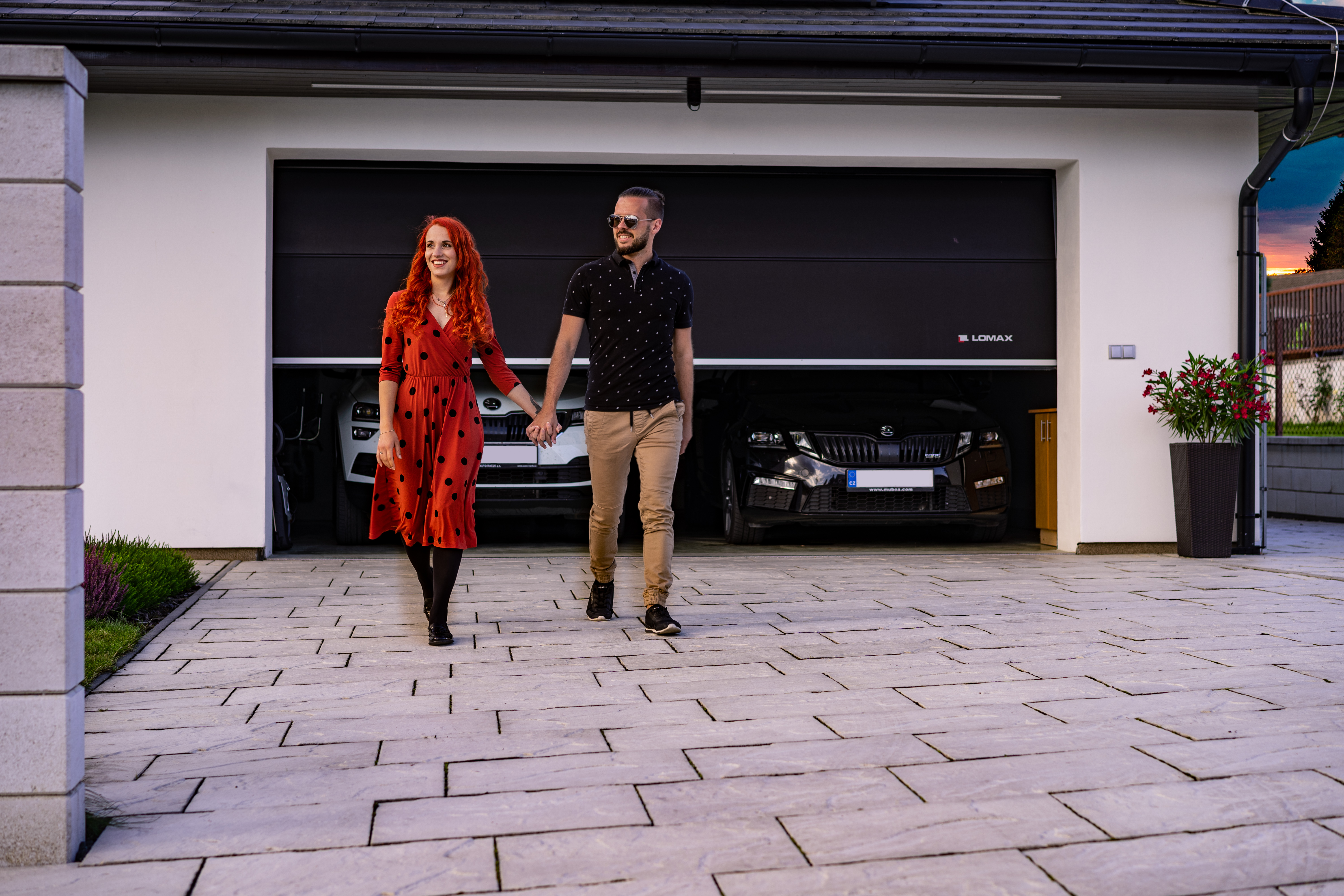 Mladý pár před otevřenou dvougaráží