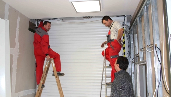 Pracovníci spoločnosti LOMAX pri montáži garážovej brány