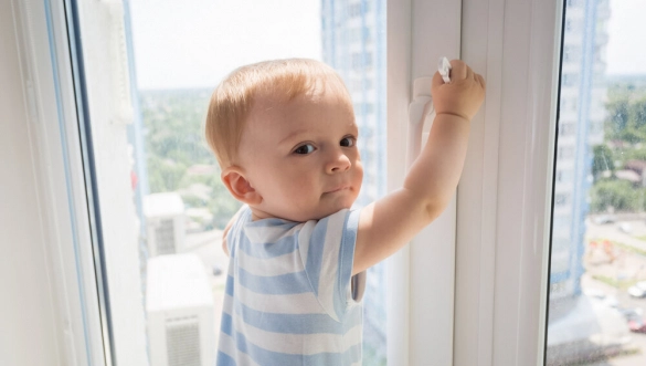 Batoľa otvára zvnútra okno v panelovom dome