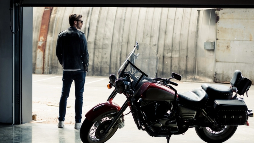 Muž s motorkou v otvorenej garáži